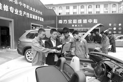 大英縣中等職業學校通過“引企入?！?，將企業維修中心建到了校園內，圖為企業專業技師向學生講解高檔轎車的保養維修技巧。